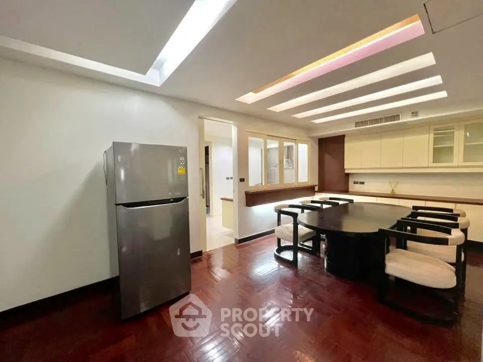 Spacious dining area with modern design and sleek refrigerator, perfect for family gatherings.