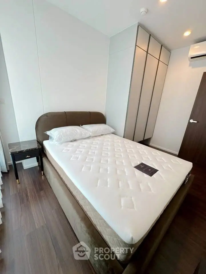 Modern bedroom with stylish bed and sleek wardrobe in a contemporary apartment.