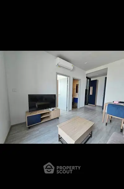 Modern living room with sleek furniture and air conditioning in a contemporary apartment.
