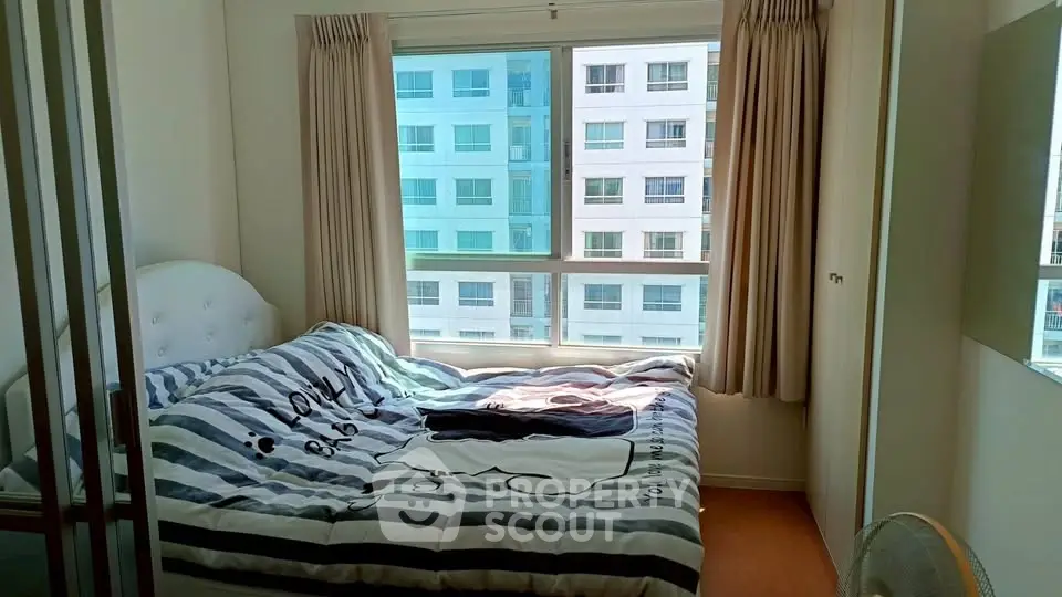 Cozy bedroom with large window and modern decor in urban apartment