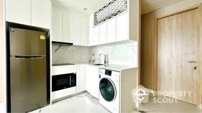 Modern kitchen with sleek appliances and marble backsplash in a stylish apartment.