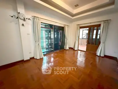 Spacious living room with wooden flooring and large windows for natural light