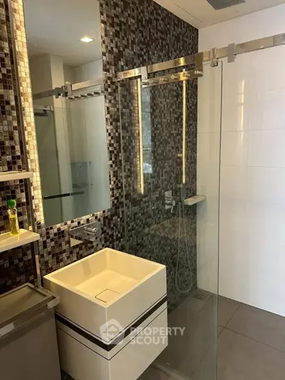 Modern bathroom with sleek glass shower and stylish mosaic tiles