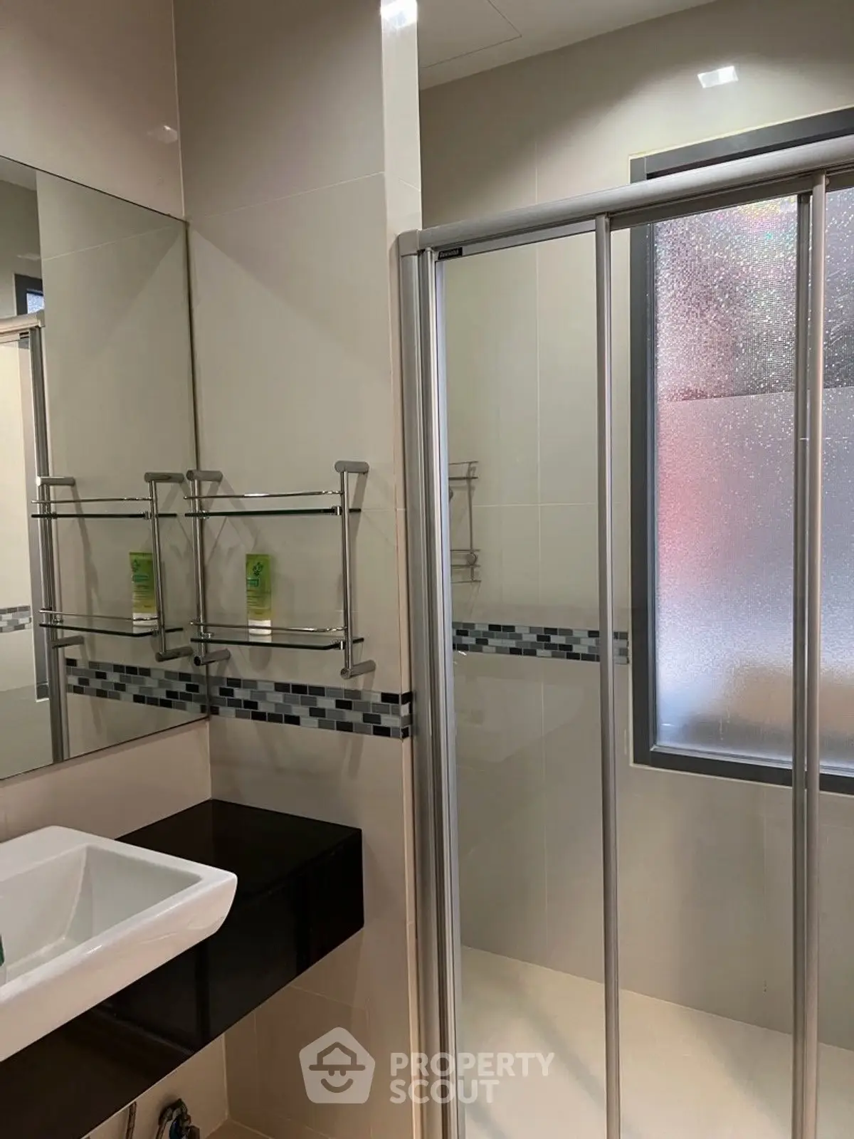 Modern bathroom with glass shower and sleek sink design.