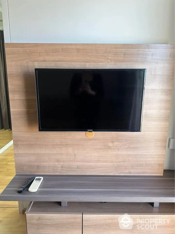 Modern living room with wall-mounted TV and sleek wooden paneling