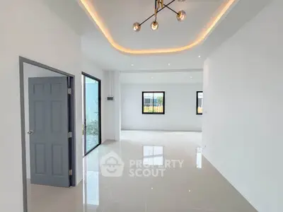 Spacious modern living room with sleek lighting and large windows for natural light.