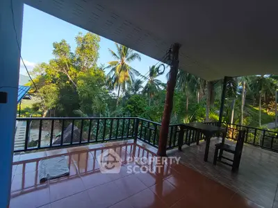 Spacious balcony with stunning tropical garden view, perfect for relaxation and outdoor dining.