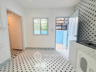 Bright kitchen with patterned tiles and open door to outdoor area