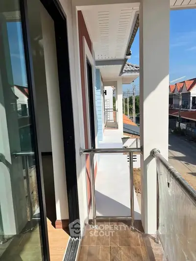 Modern balcony with sleek railing and view of residential street