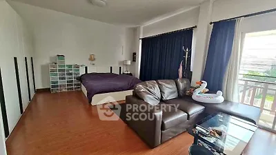 Spacious bedroom with cozy seating area and large window view