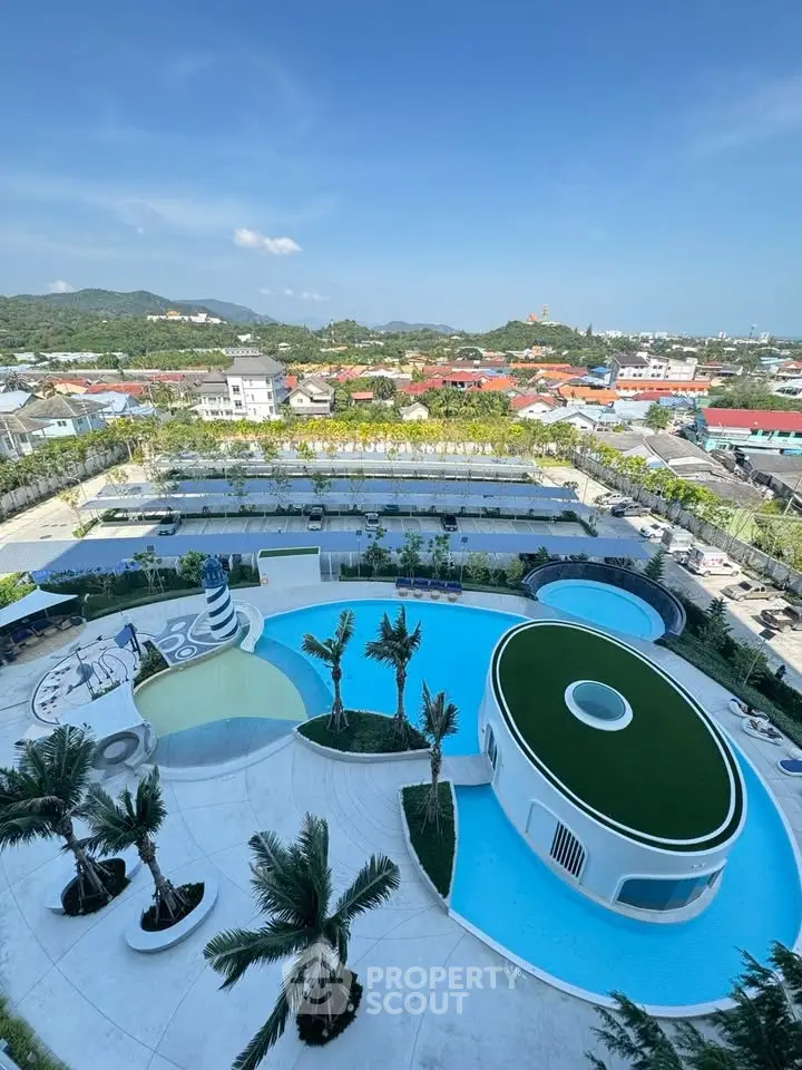 Stunning aerial view of modern pool area with lush greenery and cityscape backdrop, perfect for luxury living.