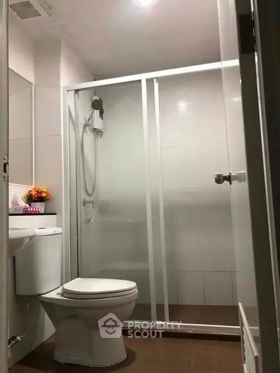 Modern bathroom with glass shower enclosure and sleek fixtures.