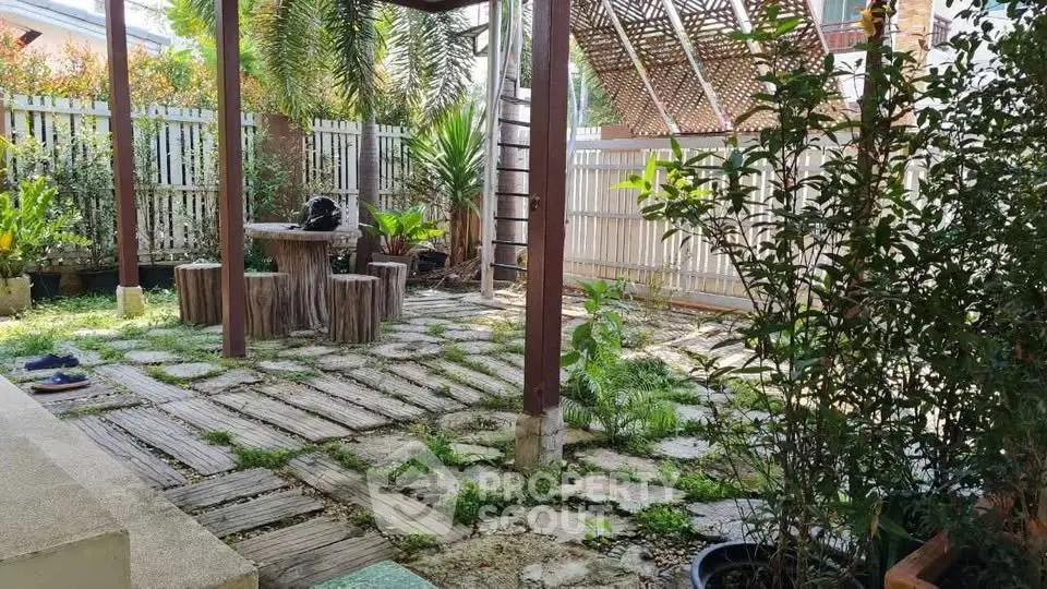 Charming backyard garden with rustic wooden seating and lush greenery