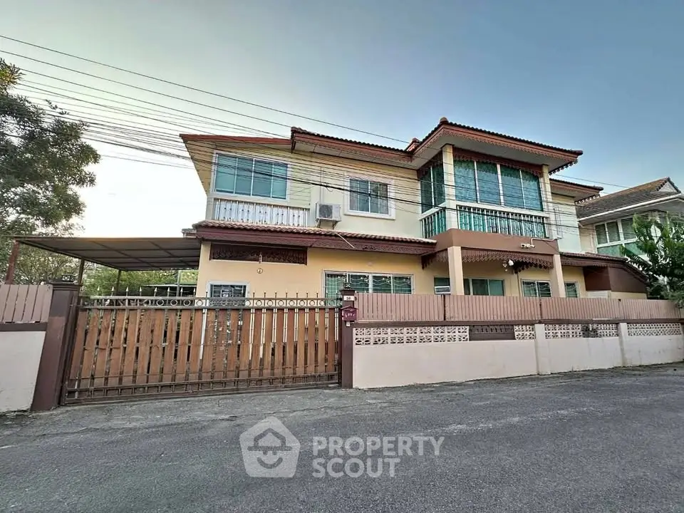 Charming two-story house with spacious driveway and gated entrance in a serene neighborhood.