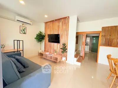 Modern living room with sleek design, featuring a wall-mounted TV, stylish furniture, and elegant decor.