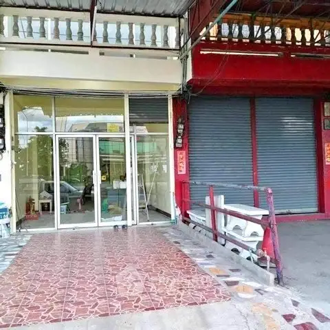 Commercial property with glass entrance and adjacent shuttered storefront