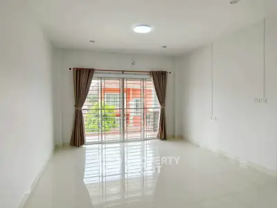 Spacious empty room with large window and elegant curtains, perfect for customization.