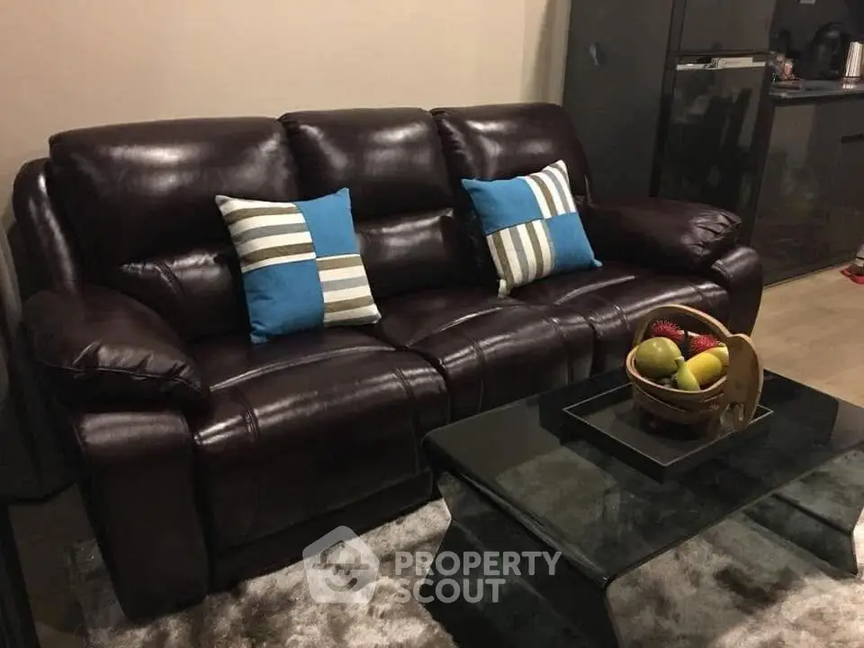 Luxurious leather sofa in modern living room with stylish decor and glass coffee table.