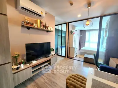 Modern living room with stylish decor and open view to bedroom, featuring sleek furniture and ambient lighting.