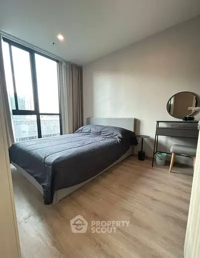 Modern bedroom with large window and stylish furnishings in urban apartment