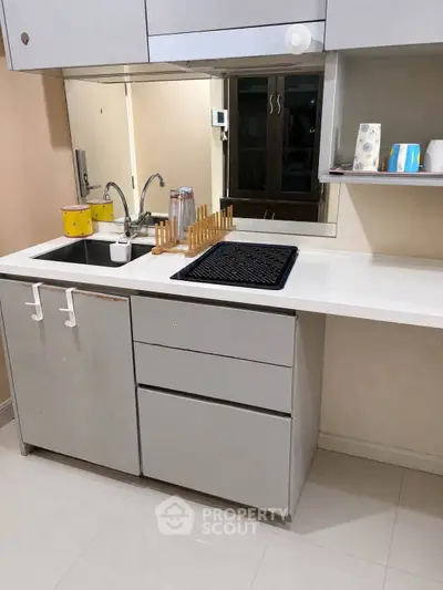 Modern kitchen with sleek cabinetry and built-in sink, featuring a minimalist design and ample counter space.