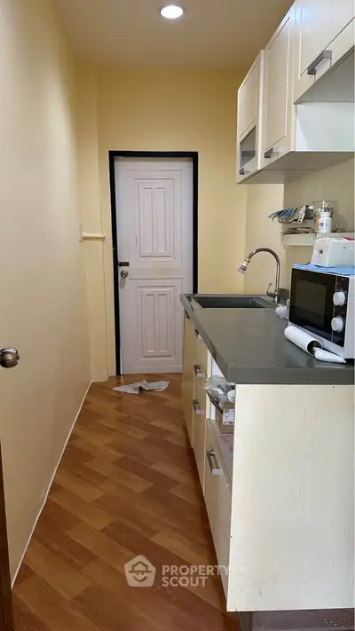 Compact kitchen with closed layout and modern appliances in cozy apartment.