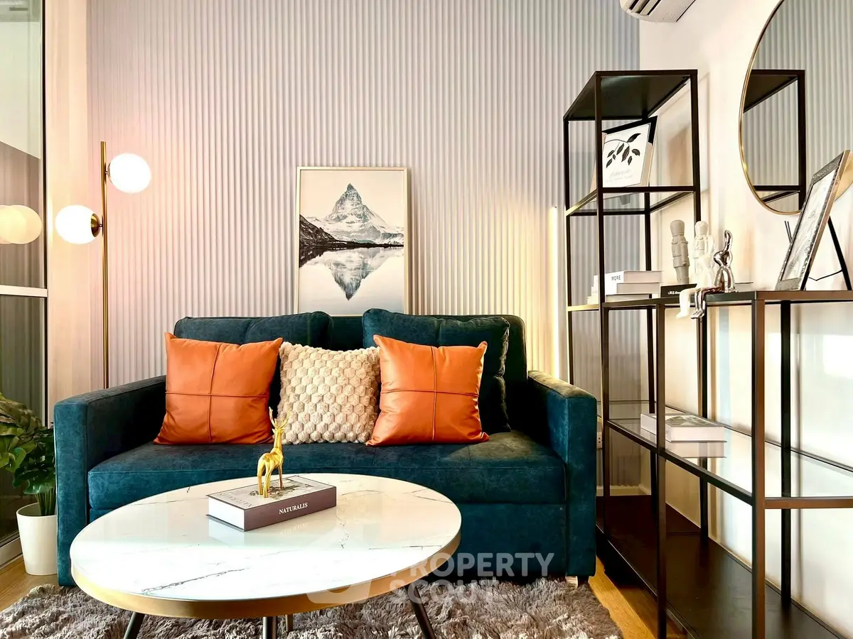 Stylish living room with modern decor, featuring a plush sofa, elegant shelving, and chic lighting.