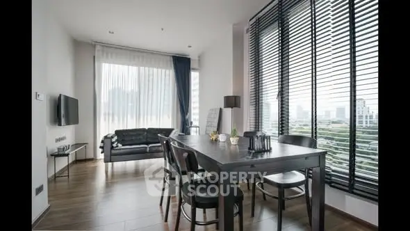 Modern living room with large windows and stylish dining area