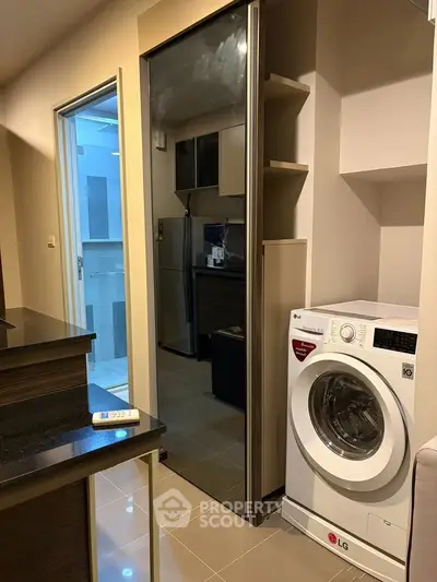 Modern kitchen with sleek appliances and washing machine in compact layout