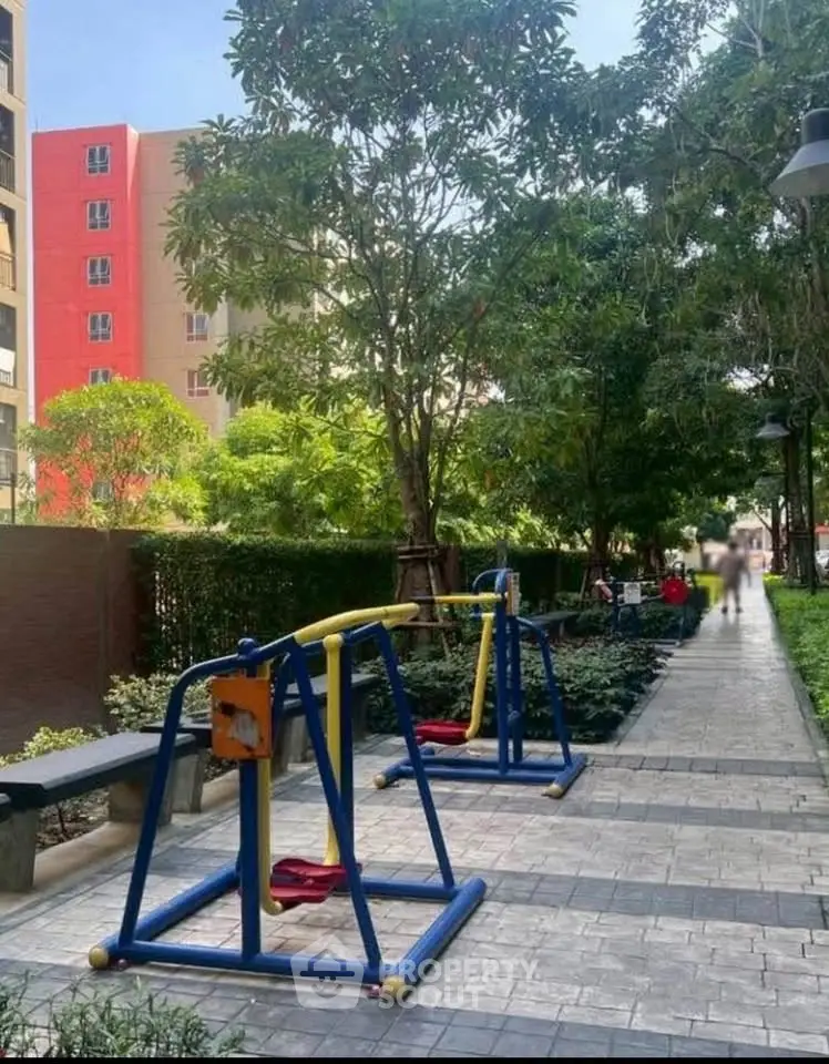Charming garden pathway with swings in a residential complex, perfect for family living.