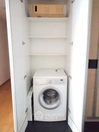 Compact laundry area with washing machine in built-in storage cabinet