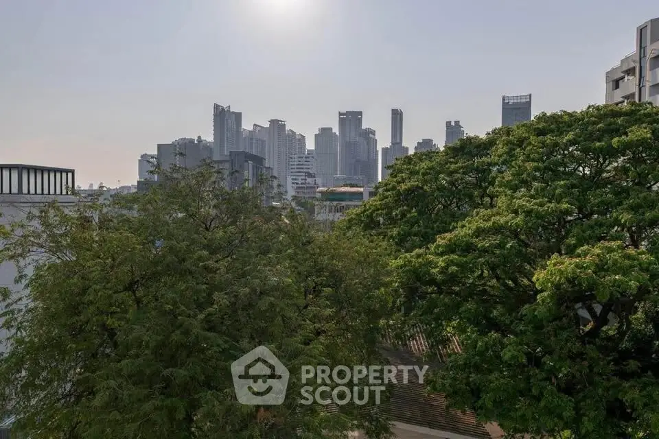 Stunning city skyline view with lush greenery in the foreground, perfect for urban living enthusiasts.