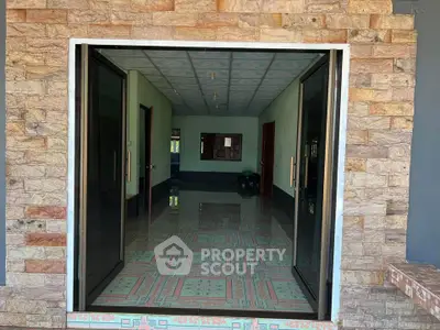 Spacious interior with stone facade and large glass doors, ideal for modern living.