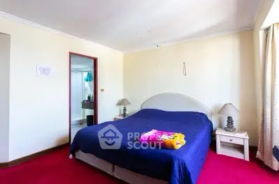 Spacious bedroom with vibrant red carpet and cozy double bed, perfect for relaxation.