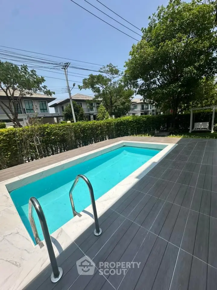Charming backyard with a pristine pool and lush greenery, perfect for relaxation and outdoor enjoyment.