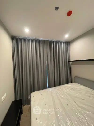 Cozy bedroom with modern design and soft lighting, featuring a large bed and elegant curtains.