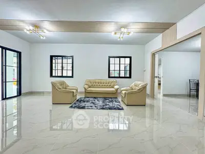 Spacious modern living room with elegant beige furniture and glossy tiled flooring.
