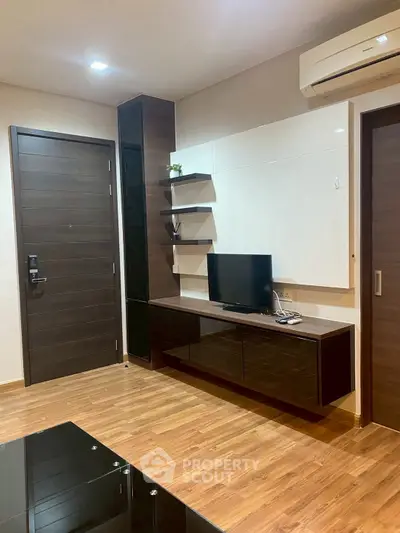 Modern living room with sleek wooden flooring and stylish TV unit