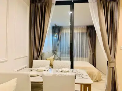 Elegant modern apartment interior with dining area and bedroom separated by glass partition.