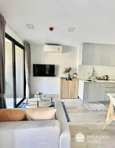 Modern living room with open kitchen, sleek design and natural light