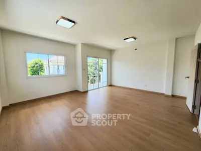 Spacious empty living room with large windows and wooden flooring