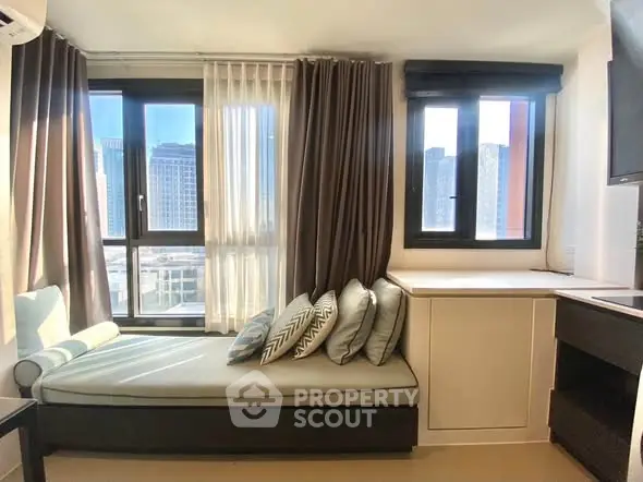 Bright modern living room with large windows and stylish seating area, offering a stunning city view.