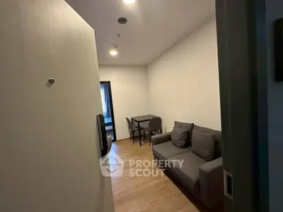 Cozy living room with modern sofa and dining table, perfect for small apartments.