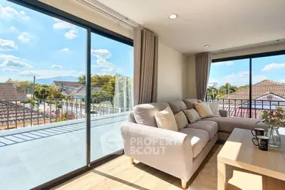 Spacious living room with large windows and balcony offering stunning views of the neighborhood.