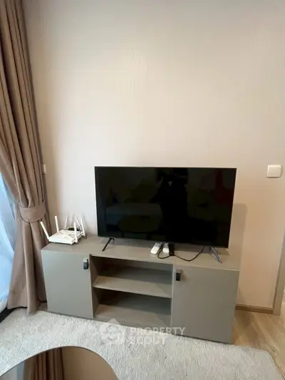 Modern living room with sleek TV stand and large flat-screen TV, perfect for entertainment.