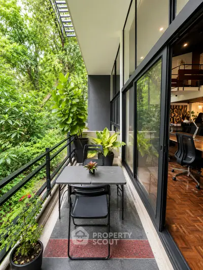 Modern balcony with lush greenery and stylish outdoor seating, perfect for relaxation and entertaining.
