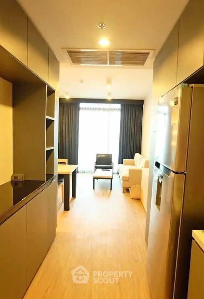 Modern apartment interior with open layout kitchen and living area, featuring sleek design and ample natural light.