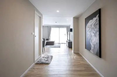 Spacious modern hallway leading to a bright living room with elegant decor.