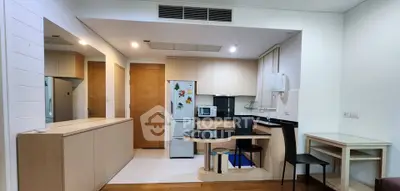 Modern kitchen with sleek cabinetry, built-in appliances, and cozy dining area in a stylish apartment.