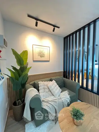 Cozy living room with green sofa, decorative plant, and modern lighting